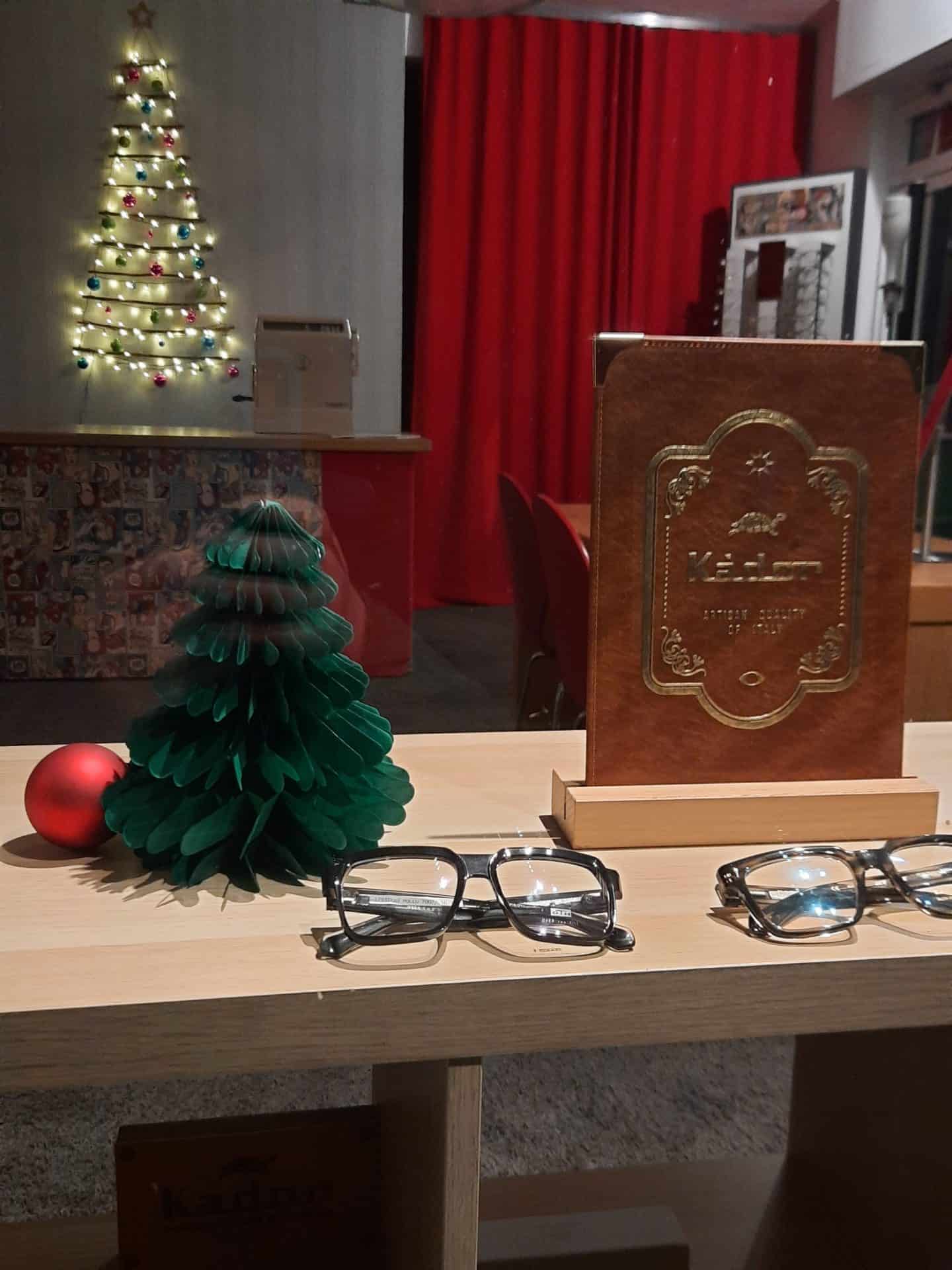 Weihnachtliche Dekoration mit Brillen auf Holzregal.