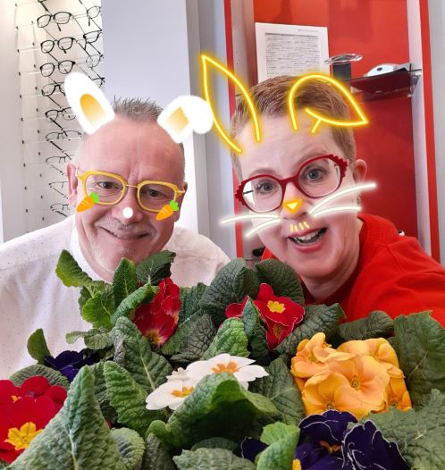 Mann und Frau mit Hasenfiltern hinter Blumen