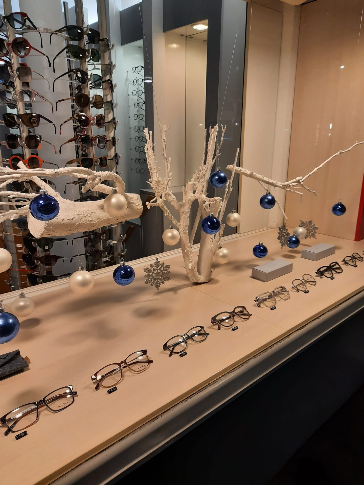 Brillen und Weihnachtsdekoration in Schaufenster ausgestellt.